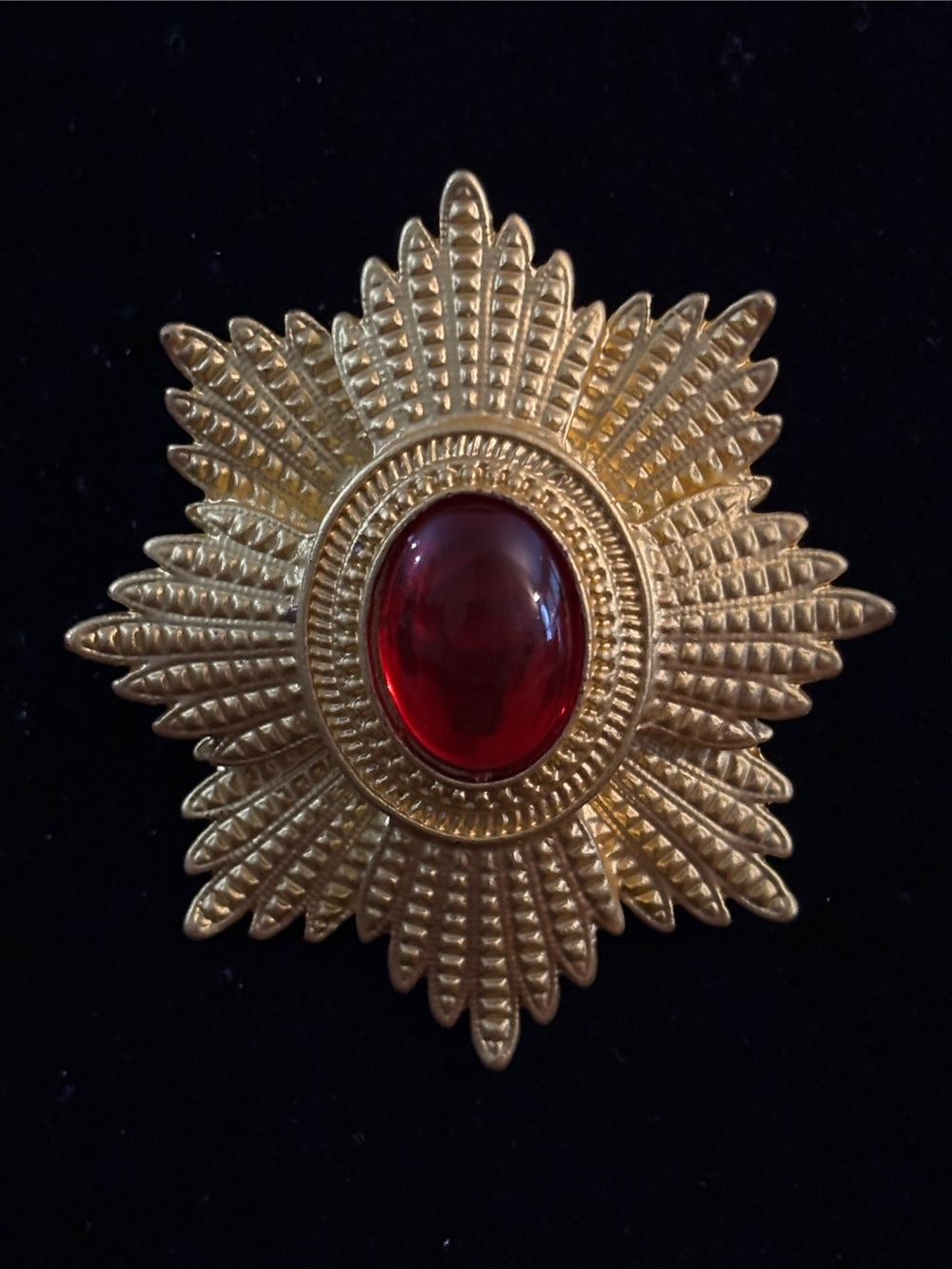Gold-Tone Starburst Brooch with Deep Red Cabochon